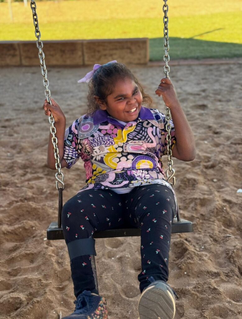 little girl smiling on swing